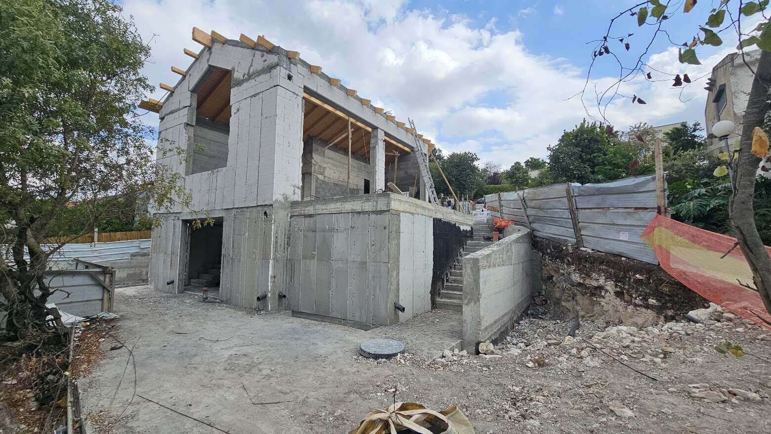 בתהליך בניה בית בעל שני קומות וגג רעפים